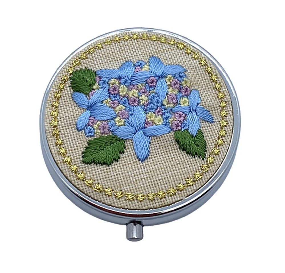 The Beauty House Pillendose mit Spiegel und gestrickten Blumen
