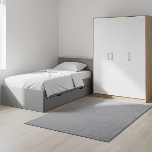 Graues Kinderbett mit weißer Bettwäsche und Schubladen, davor ein grauer Teppich, daneben ein weißer Kleiderschrank mit Eiche-Seiten.