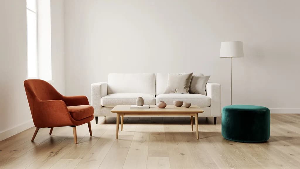 Helles Wohnzimmer mit cremeweißem Bouclé-Sofa, terracottafarbenem Sessel und petrolfarbenem Samthocker auf Eichenboden.
