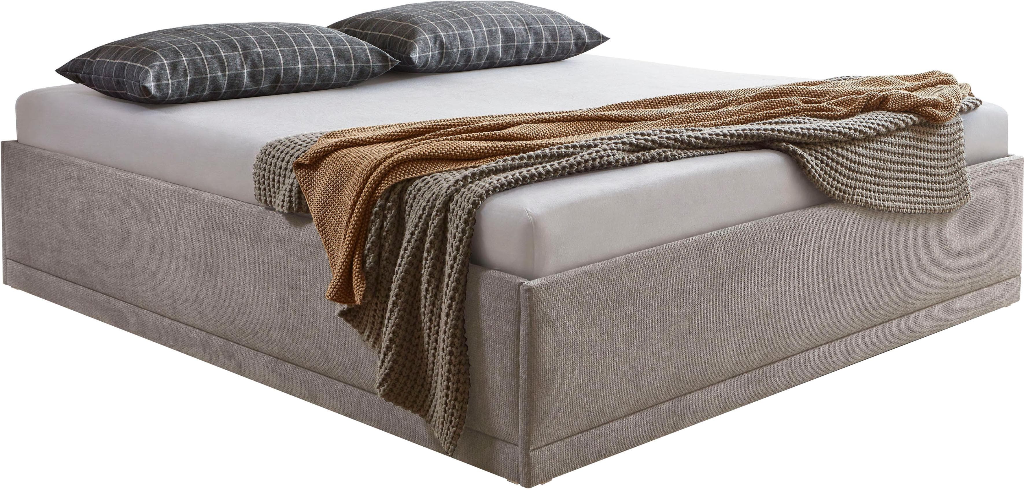 Komfortables Polsterbett mit Zierkissen und Bettkasten